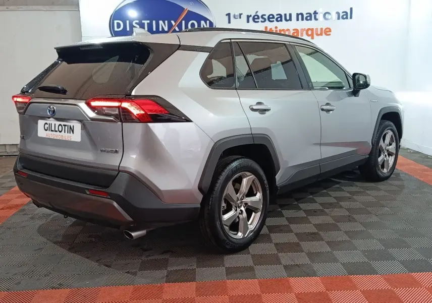 Vue 3/4 arrière droite du Toyota RAV4 hybride 2WD gris avec feux arrière LED et jantes alliage.