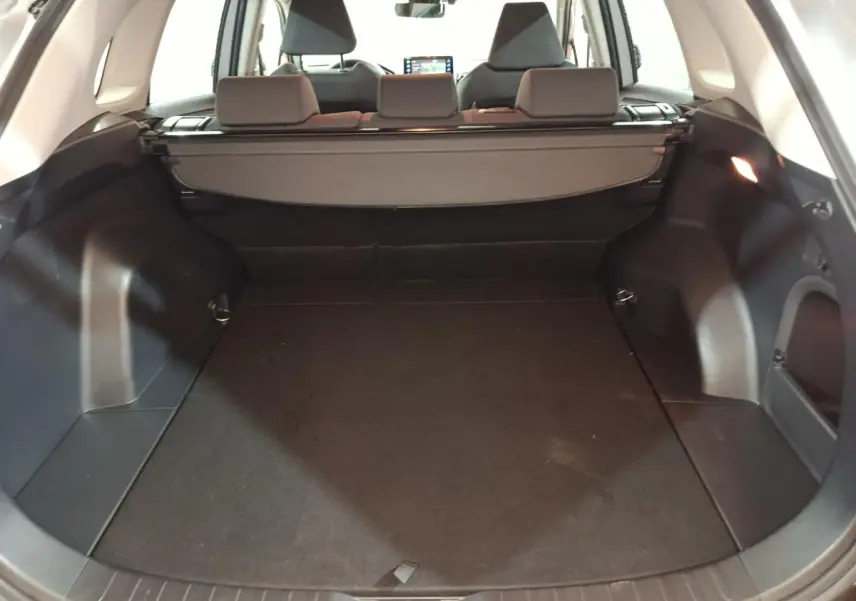 Coffre ouvert du Toyota RAV4 hybride 2WD 2021, vue arrière, intérieur noir avec cache-bagages déployé.
