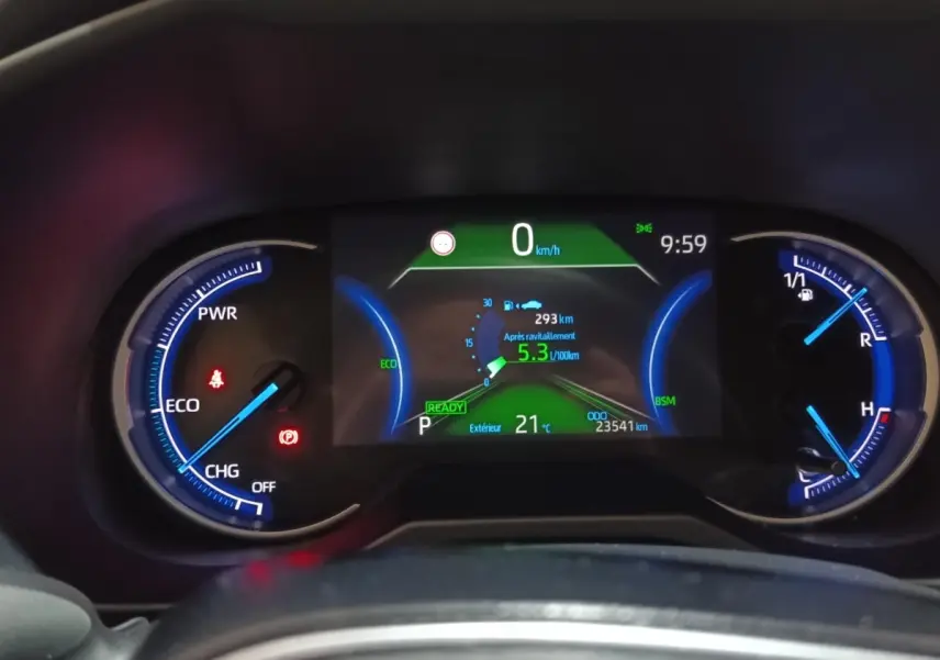 Tableau de bord numérique du Toyota RAV4 hybride 2021, affichage consommation et température extérieure à 21°C.