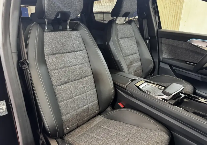 Vue intérieure côté gauche des sièges avant en tissu gris et cuir noir du Renault Espace 2025 techno 7PL E-Tech hybride.