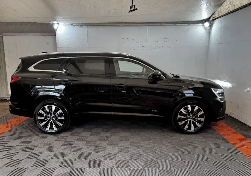 Profil droit du Renault Espace noir 2025 avec jantes alliage et rails de toit chromés en intérieur fermé.