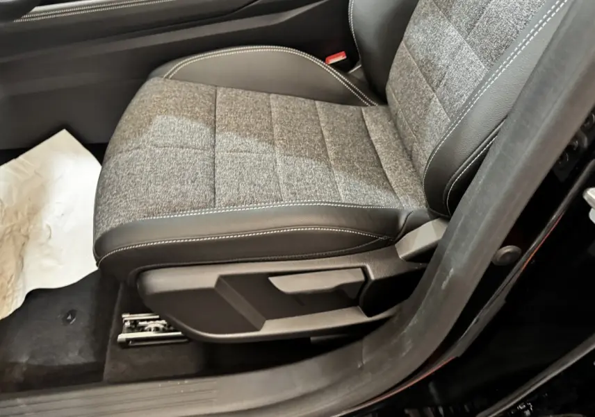 Gros plan sur le siège avant droit gris et noir du Renault Espace Techno 7PL E-Tech hybride noir 2025.