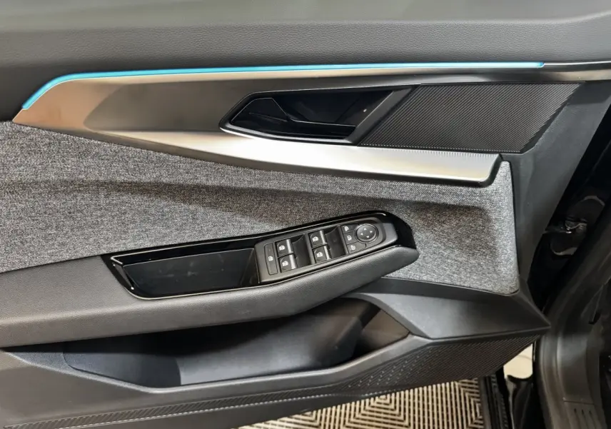 Détail de la porte avant gauche du Renault Espace 2025, avec commandes de vitres et insert textile gris.
