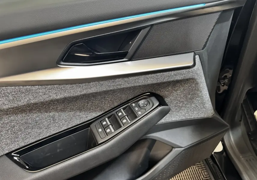 Détail de la porte côté conducteur du Renault Espace 2025, avec commandes de vitres et garniture tissu grise.