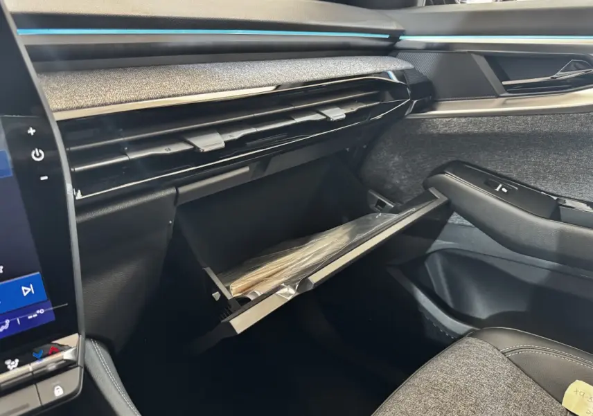 Intérieur côté passager du Renault Espace 2025 noir, montrant la boîte à gants ouverte et la finition tissu et cuir.
