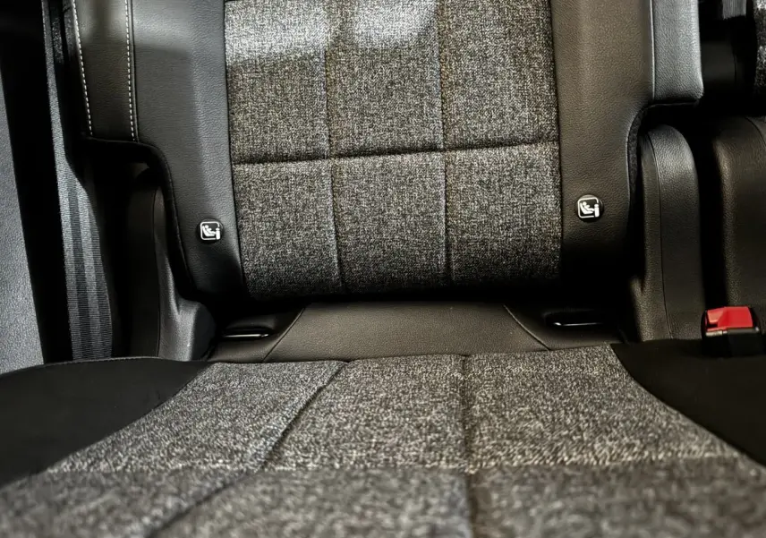 Gros plan sur la banquette arrière grise et noire du Renault Espace 2025, montrant les fixations Isofix et la ceinture rouge.