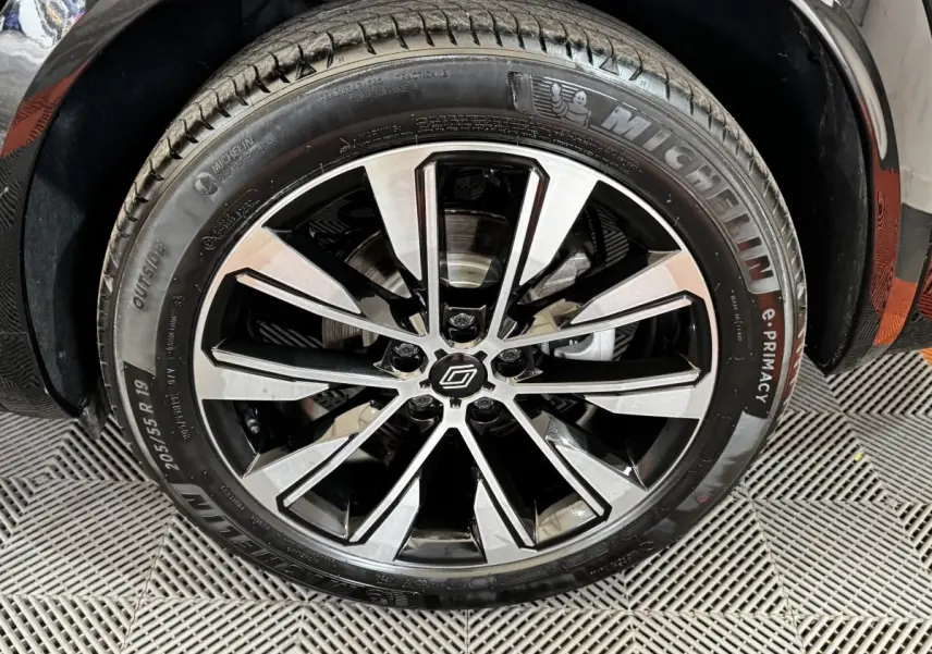 Gros plan sur la roue avant droite noire du Renault Espace 2025 avec jante alliage bicolore et pneu Michelin.