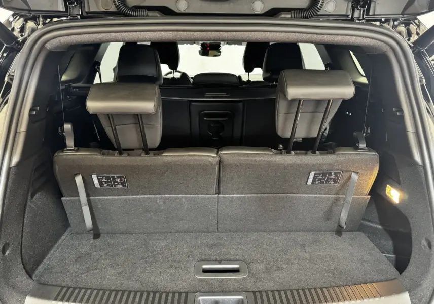 Vue intérieure du coffre arrière du Renault Espace noir 2025 avec sièges rabattables en position verticale.