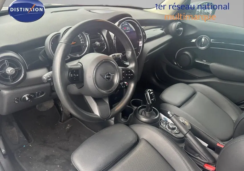 Intérieur noir de la MINI 1.5 136CH 2023 vu côté conducteur, avec volant cuir et console centrale moderne.