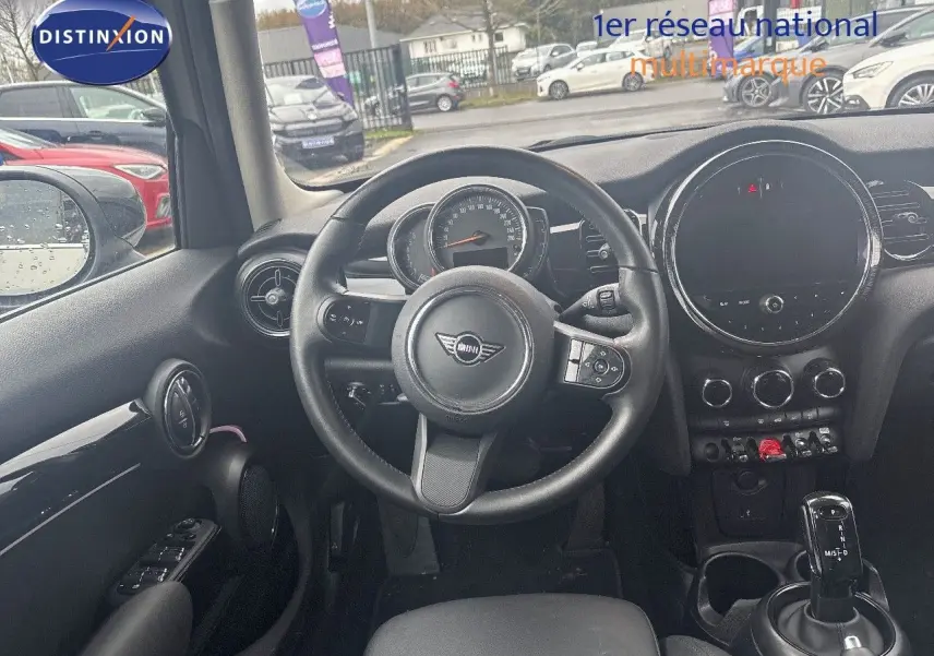 Vue intérieure centrée sur le volant et le tableau de bord d'une MINI 1.5 136CH gris rooftop avec boîte auto.