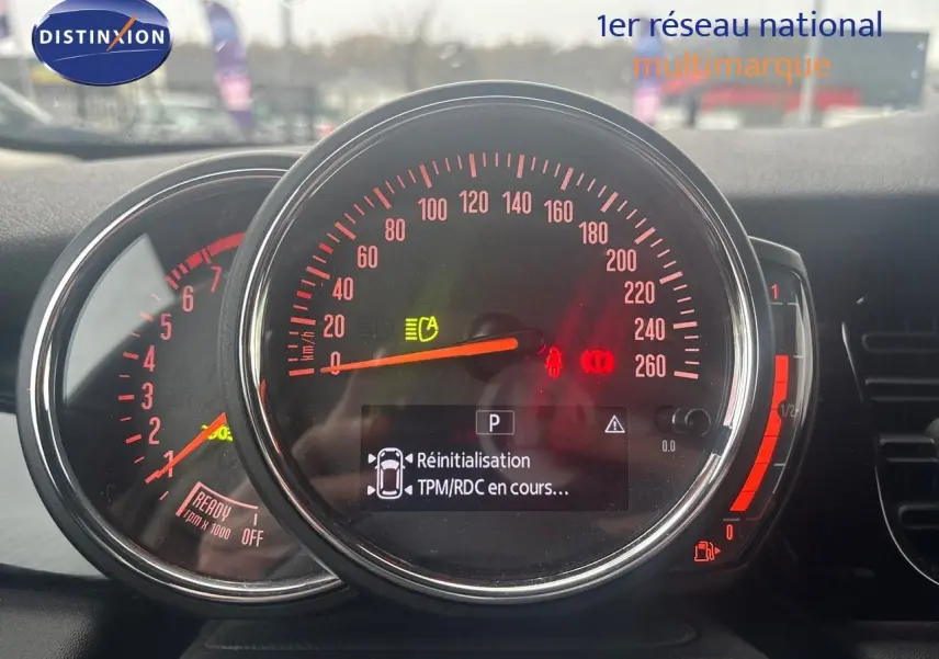 Tableau de bord de MINI 2023 avec compteur central et affichage digital, éclairage rouge et gris rooftop visible.