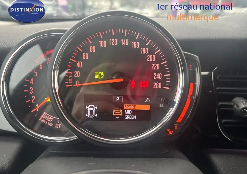 Gros plan sur le tableau de bord de la MINI 1.5 136CH STEPTRONIC 2023 avec affichage digital et compteurs rouges.