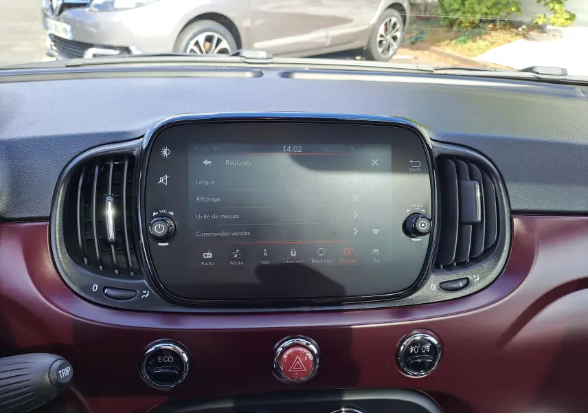 Vue intérieure du tableau de bord de la Fiat 500 2020, avec écran tactile et finition bordeaux Opera visible.