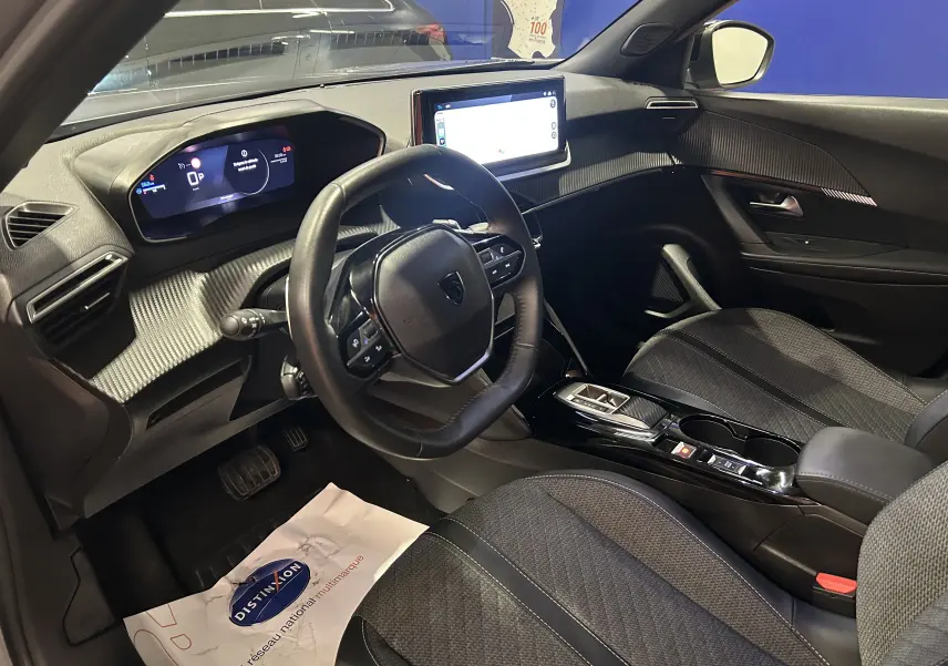 Intérieur du Peugeot 2008 Allure Hybrid 2025 vu côté conducteur, tableau de bord numérique et écran tactile central.