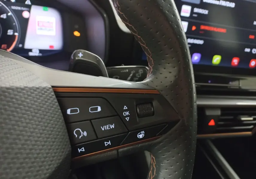 Gros plan sur le volant perforé noir avec commandes intégrées et éclairage d'ambiance intérieur du CUPRA Formentor 2023.