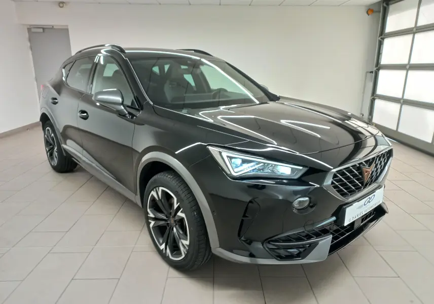 CUPRA Formentor noir minuit en 3/4 avant droit, avec jantes 18'' Performance Black et phares allumés.