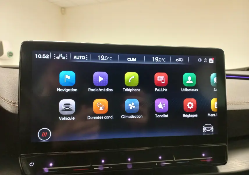 Écran tactile central du tableau de bord du CUPRA Formentor 2023 avec interface multimédia et éclairage d'ambiance violet.