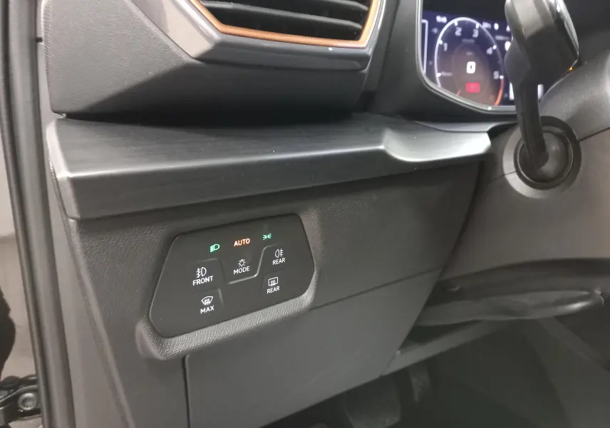 Détail du tableau de bord côté gauche du CUPRA Formentor 2023 noir, avec commandes d'éclairage et finition noire mate.