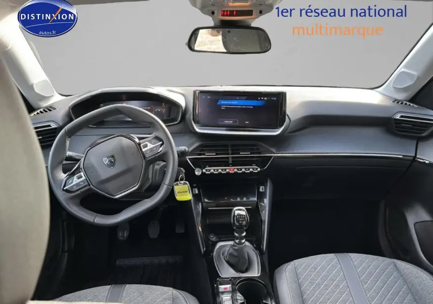 Vue intérieure avant de la Peugeot 208 2024 noire, avec tableau de bord moderne et boîte manuelle visible.