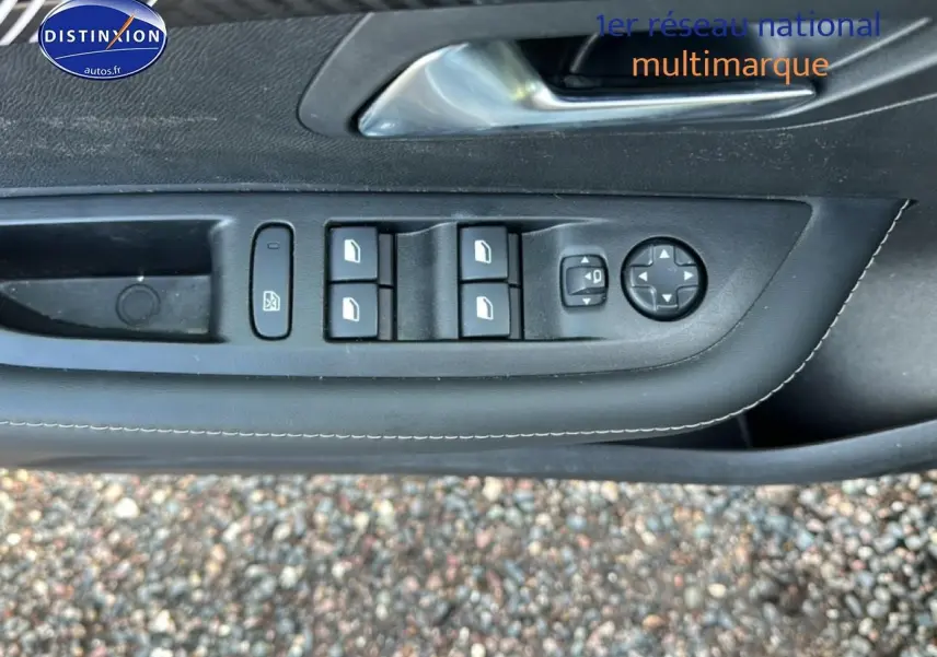 Vue rapprochée des commandes des vitres et rétroviseurs sur la porte côté gauche d'une Peugeot 208 noire 2024.