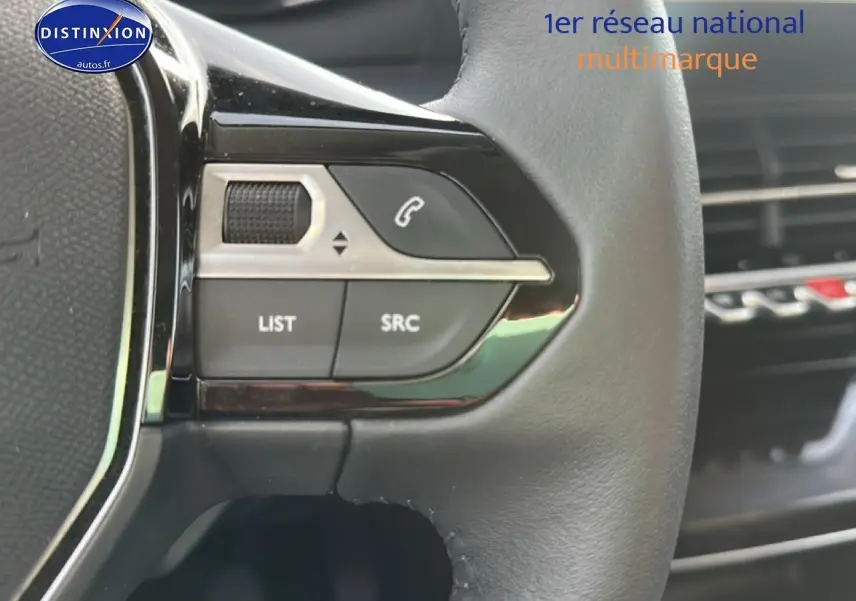 Gros plan sur les commandes gauche du volant cuir noir de la Peugeot 208 1.2 PureTech 100 Allure 2024.