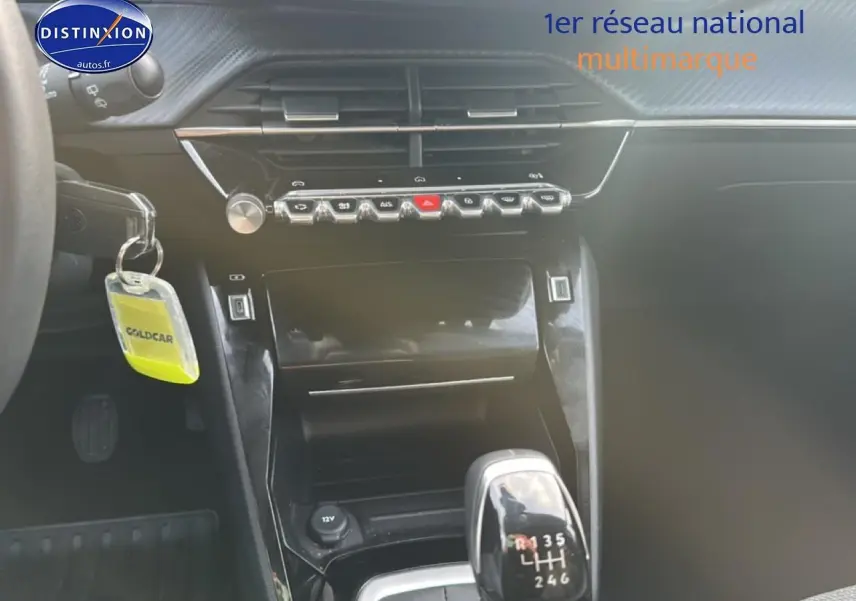 Intérieur de la Peugeot 208 1.2 PureTech 100 allure 2024, vue centrée sur la console avec levier de vitesses manuel noir brillant.
