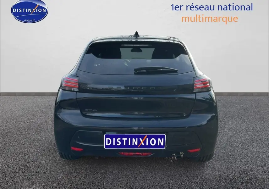 Vue arrière d'une Peugeot 208 noire 2024 avec feux LED et lunette arrière surteintée sur sol goudronné.