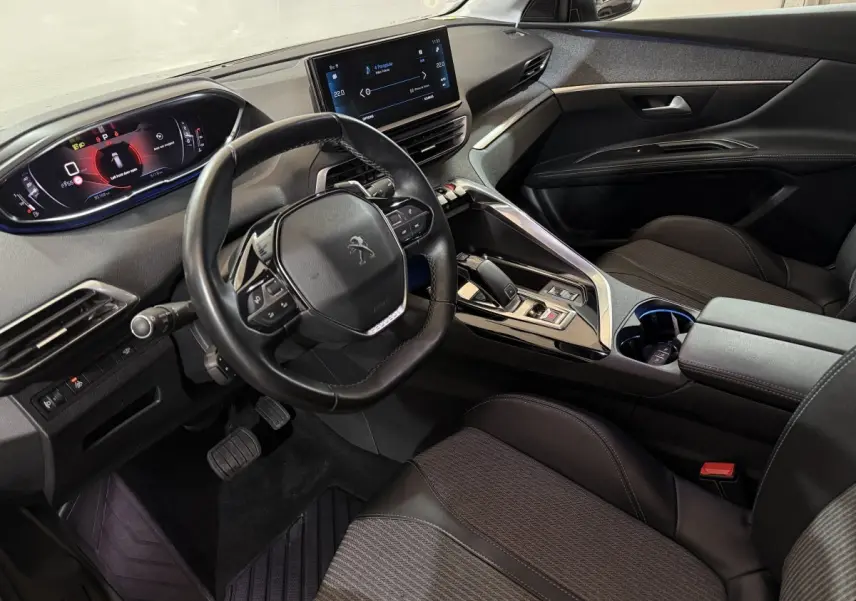 Intérieur noir du Peugeot 5008 2021 vu côté conducteur, avec volant cuir compact et écran tactile central.