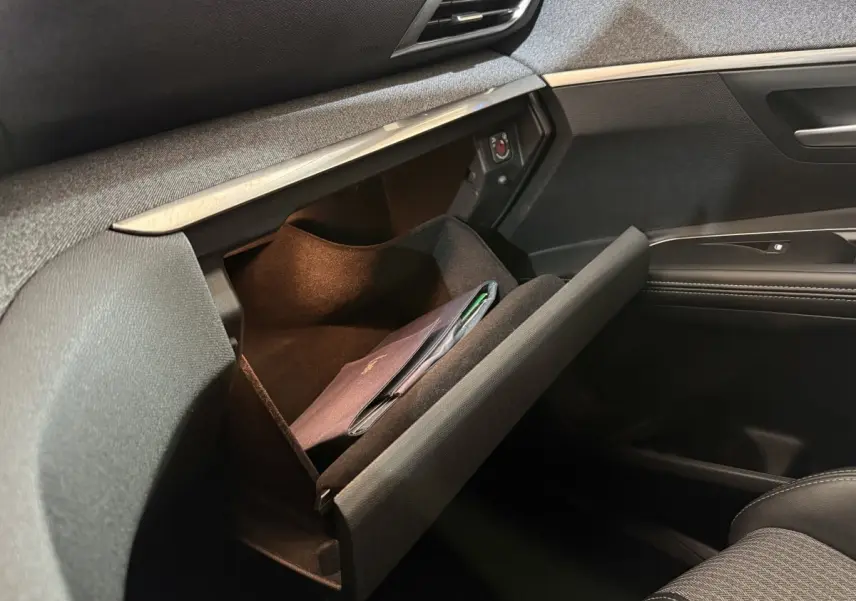 Vue intérieure côté passager du Peugeot 5008 gris clair 2021, boîte auto, avec boîte à gants ouverte et livret à l'intérieur.