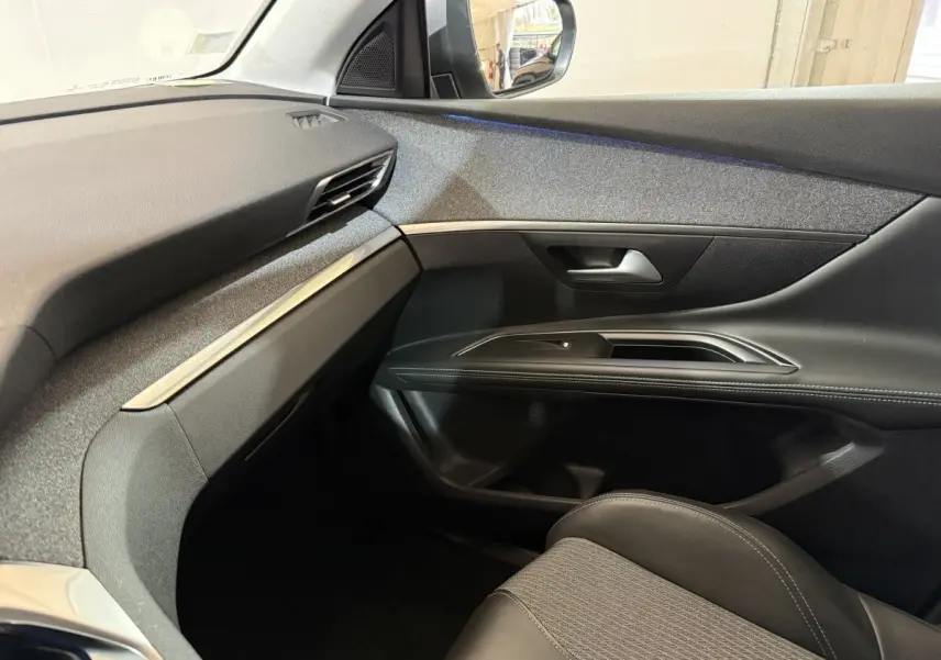Vue intérieure côté passager du Peugeot 5008 2021 gris clair, montrant la portière et le tableau de bord épuré.