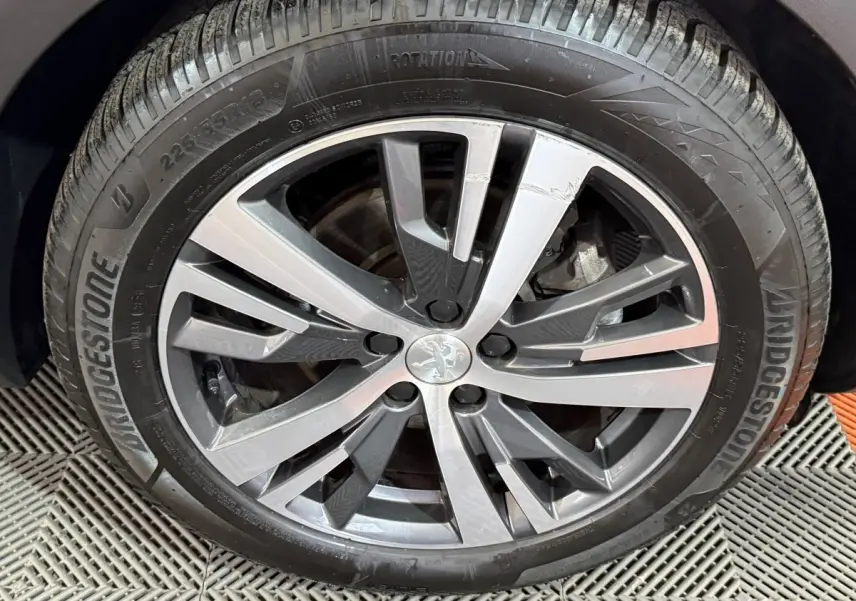 Gros plan sur la jante alliage gris foncé du Peugeot 5008 gris clair, avec pneu Bridgestone visible.