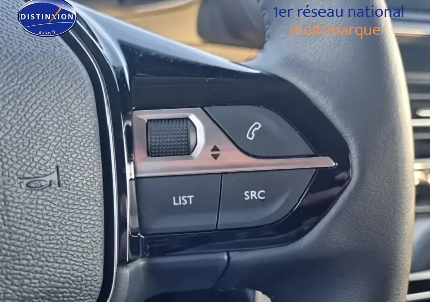 Gros plan sur les commandes audio au volant d'une Peugeot 208 1.2 100 Allure gris Artense, côté gauche.