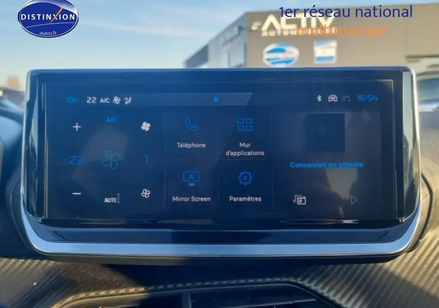 Écran tactile central affichant la climatisation et les applications, intérieur d'une Peugeot 208 gris artense.