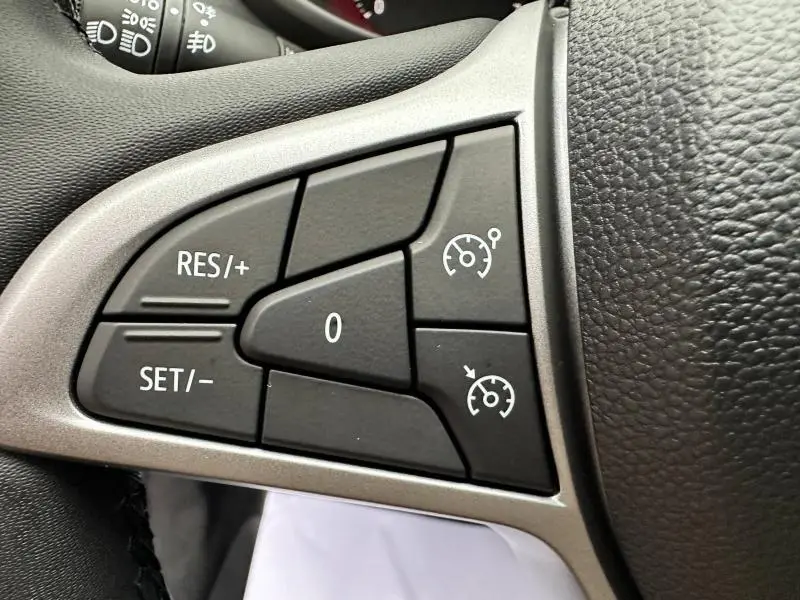Gros plan sur les commandes de régulateur de vitesse au volant du Dacia Jogger gris Schiste métallisé.