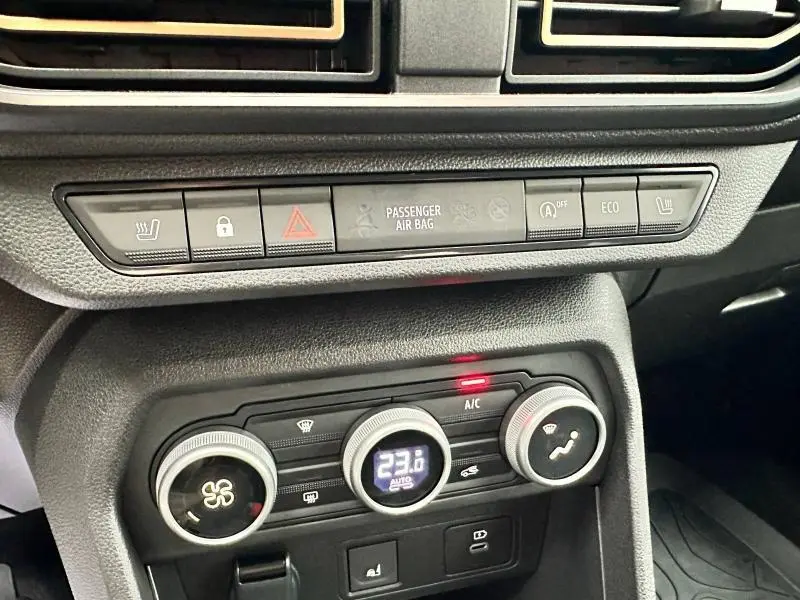 Détail du tableau de bord du Dacia Jogger 2024 montrant les commandes de climatisation et les boutons de sécurité.