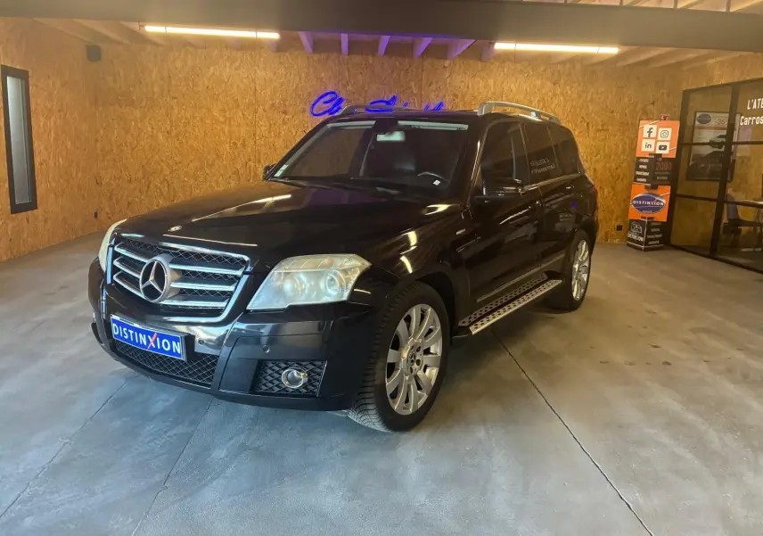 Mercedes GLK noir vue 3/4 avant droit dans un garage avec calandre chromée et jantes alliage.