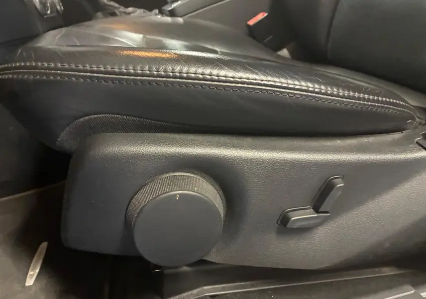 Gros plan sur les commandes de réglage électrique du siège en cuir noir côté conducteur du Mercedes GLK 220 CDI 2012.