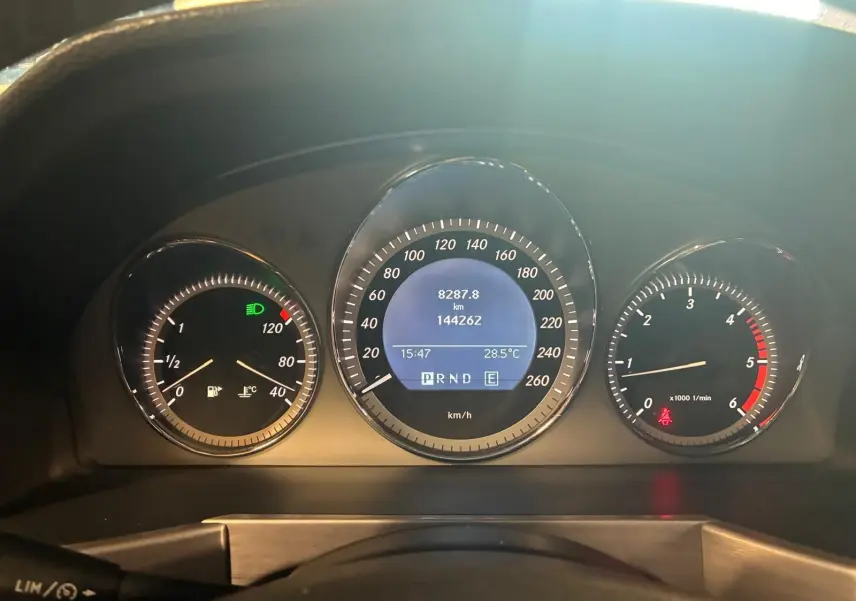 Vue rapprochée du tableau de bord noir du Mercedes GLK 220 CDI, affichant compteurs et indicateurs digitaux.