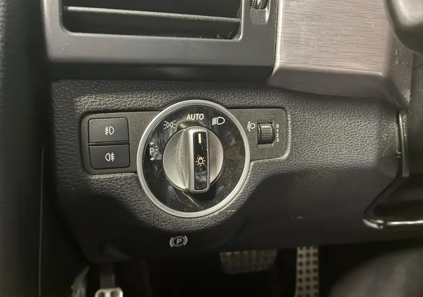 Gros plan sur le bouton de commande des phares dans l’habitacle noir du Mercedes GLK 220 CDI Phase 2.