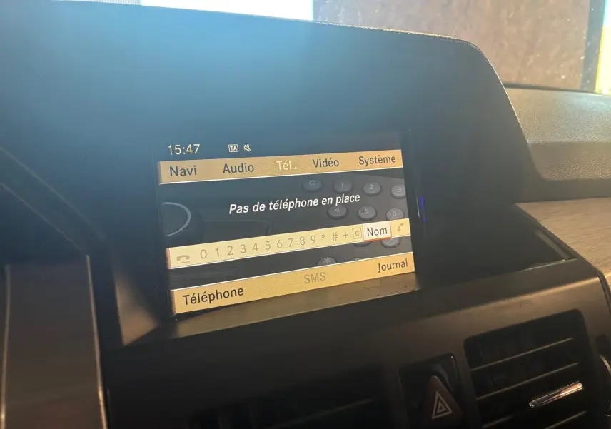 Écran central du système multimédia d’une Mercedes GLK noire de 2012, affichant le menu téléphone sans appareil connecté.