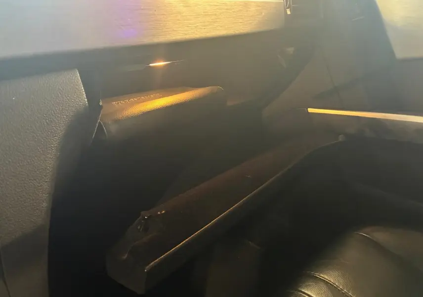 Intérieur noir du Mercedes GLK 220 CDI 2012, vue sur la boîte à gants ouverte côté passager avec éclairage doux.