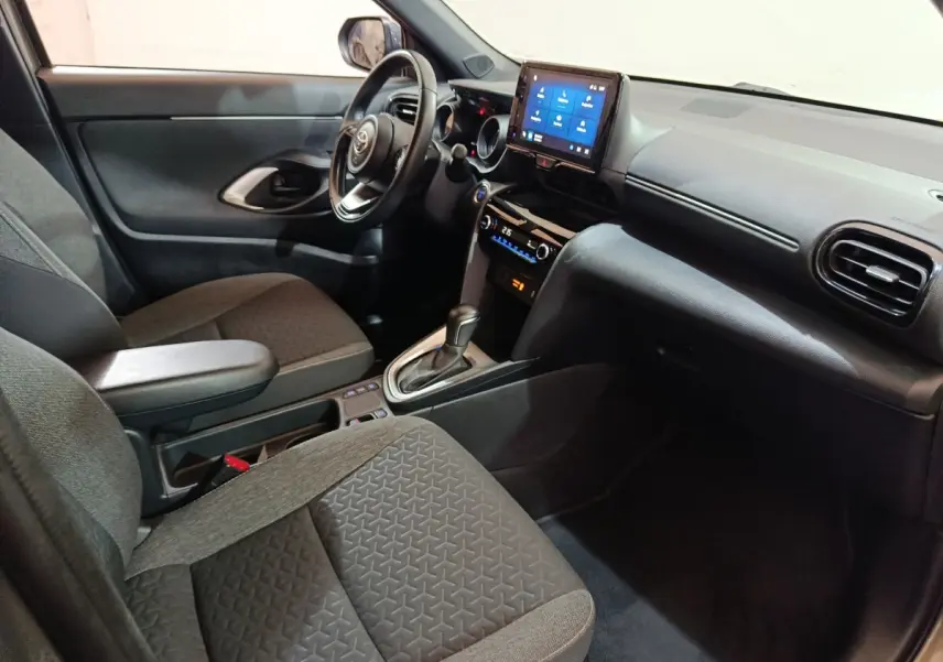 Vue intérieure côté conducteur de la Toyota Yaris Cross 2022, avec tableau de bord noir et écran tactile central.