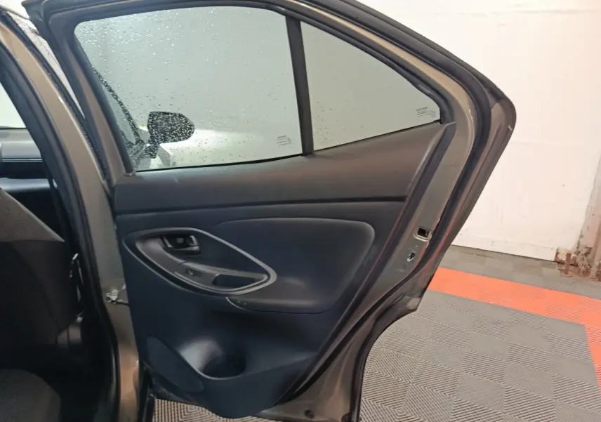 Vue intérieure de la porte arrière droite grise foncée du Toyota Yaris Cross 1.5 Hybrid 2022 avec accoudoir et commandes.