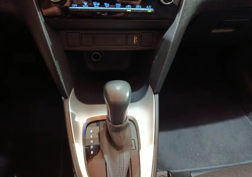 Vue rapprochée du levier de vitesses automatique noir sur console argentée dans l’habitacle du Toyota Yaris Cross gris foncé.