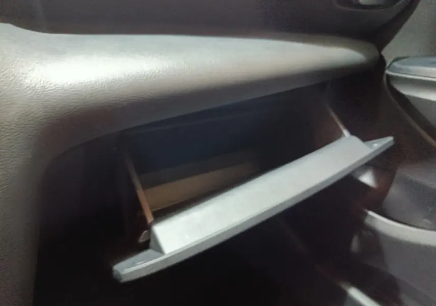 Gant de boîte à gants ouvert côté passager intérieur du Toyota Yaris Cross gris foncé 2022.