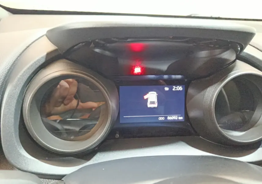 Vue rapprochée du combiné d'instruments numérique de la Toyota Yaris Cross 2022, affichant une alerte porte ouverte.