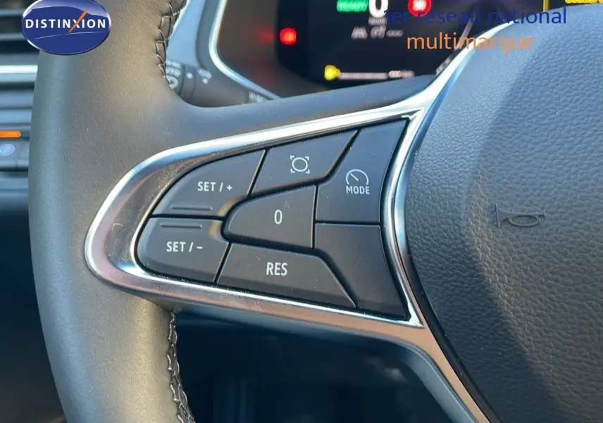 Gros plan sur les commandes de régulateur de vitesse au volant cuir du Renault Captur E-Tech hybride 2025.