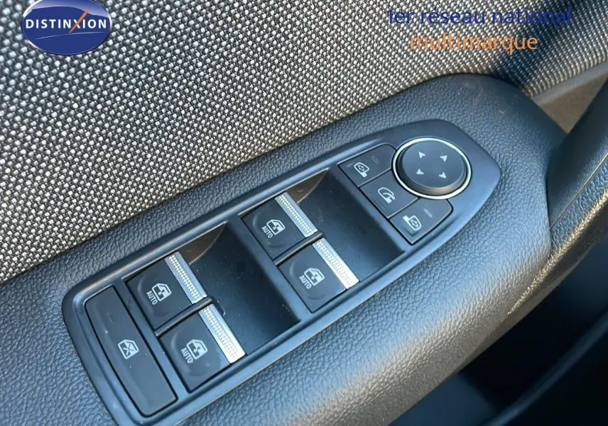 Commande des vitres électriques et réglage des rétroviseurs sur la porte côté gauche d'un Renault Captur bleu Iron Metal toit noir.