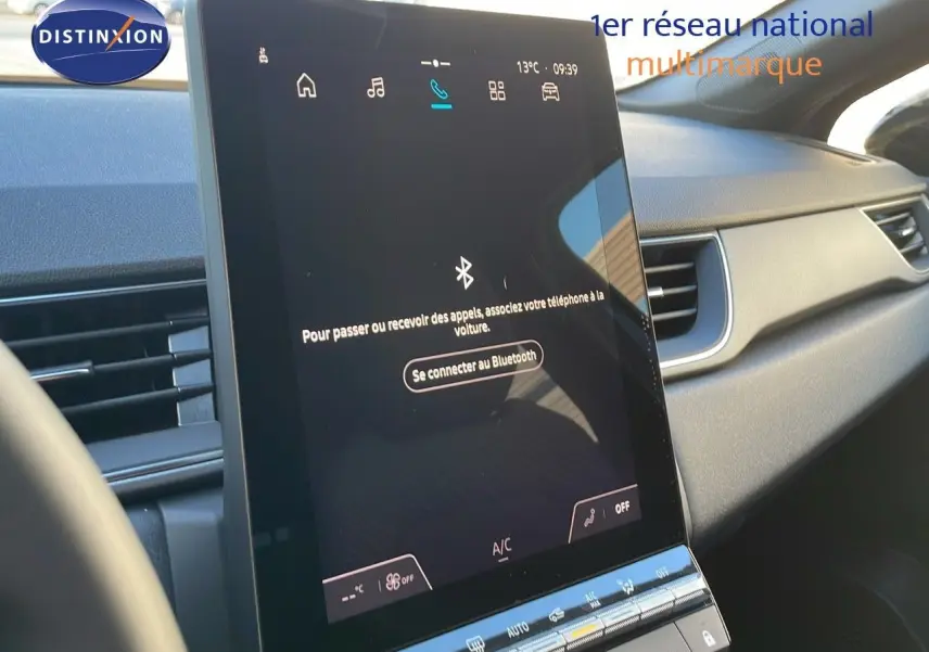 Écran tactile central affichant la connexion Bluetooth dans l’habitacle moderne d’un Renault Captur bleu Iron Metal toit noir.
