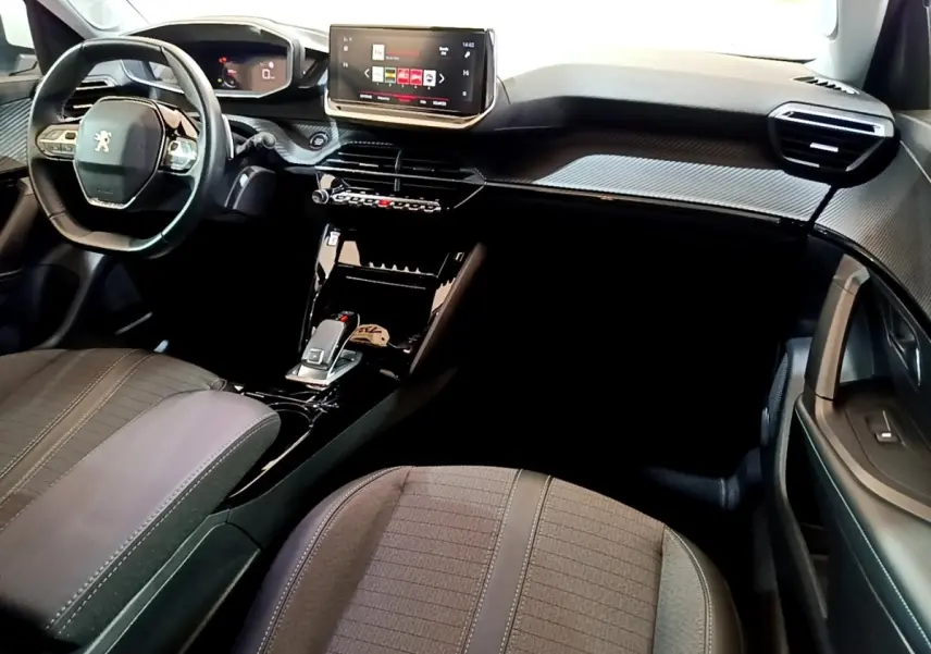 Intérieur avant droit du Peugeot 2008 2021, tableau de bord noir avec écran tactile et volant cuir multifonctions.